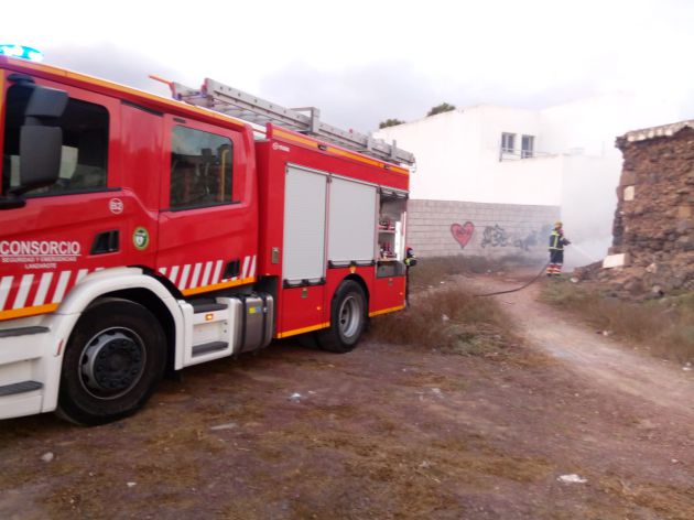 Bombero apagando el incendio de maderas en San Bartolomé. Bombero apagando el incendio de maderas en San Bartolomé.