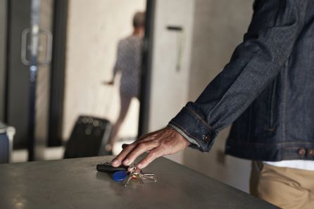 Un joven deja las llaves del piso sobre una mesa Un joven deja las llaves del piso sobre una mesa