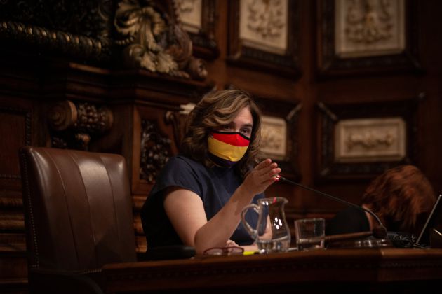 La alcaldesa de Barcelona, Ada Colau, con una mascarilla de la bandera republicana, interviene en el Pleno del Ayuntamiento, el último que se celebra antes del parón estival y el primero que tiene lugar con el retrato del rey colocado de nuevo en la sala de plenos. La alcaldesa de Barcelona, Ada Colau, con una mascarilla de la bandera republicana, interviene en el Pleno del Ayuntamiento, el último que se celebra antes del parón estival y el primero que tiene lugar con el retrato del rey colocado de nuevo en la sala de plenos.