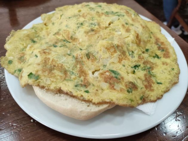 Tortilla floja con cebolla, pan rallado y perejil dejada caer sobre el pan Tortilla floja con cebolla, pan rallado y perejil dejada caer sobre el pan