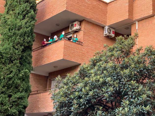 Trabajadoras residencia Los Olmos presenciando el acto desde un balcón Trabajadoras residencia Los Olmos presenciando el acto desde un balcón