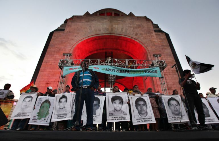 Felipe de la Cruz, the father of one of the 43 missing students from the Isidro Burgos rural teachers college, speaks to a crowd in front of other relatives holding posters of their missing loved ones, during a protest at the Revolution Monument in Mexico City, Saturday, Dec. 6, 2014. At least one of the college students missing since September has been identified among charred remains found near a garbage dump, two Mexican officials confirmed Saturday. A family member of a missing student told The Associated Press that the remains were of Alexander Mora. The students went missing Sept. 26 after confrontations with police in Iguala, in southern Guerrero state, that killed three students and three bystanders. (AP Photo/Marco Ugarte) Felipe de la Cruz, the father of one of the 43 missing students from the Isidro Burgos rural teachers college, speaks to a crowd in front of other relatives holding posters of their missing loved ones, during a protest at the Revolution Monument in Mexico City, Saturday, Dec. 6, 2014. At least one of the college students missing since September has been identified among charred remains found near a garbage dump, two Mexican officials confirmed Saturday. A family member of a missing student told The Associated Press that the remains were of Alexander Mora. The students went missing Sept. 26 after confrontations with police in Iguala, in southern Guerrero state, that killed three students and three bystanders. (AP Photo/Marco Ugarte)