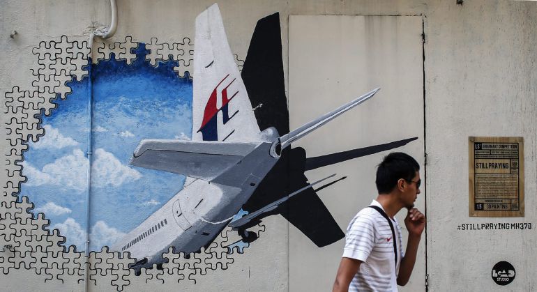 Un hombre camina junto a un mural del vuelo desaparecido de Malaysia Airlines hace un año. Un hombre camina junto a un mural del vuelo desaparecido de Malaysia Airlines hace un año.