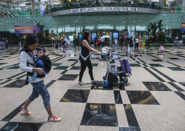 Un grupo de personas buscan las puertas de embarque en el aeropuerto de Singapur. Un grupo de personas buscan las puertas de embarque en el aeropuerto de Singapur.