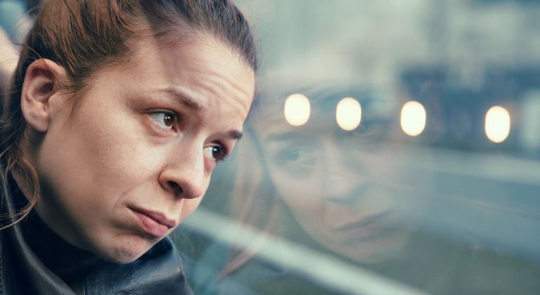 Imagen de una mujer triste frente al cristal de un autobús. Imagen de una mujer triste frente al cristal de un autobús.