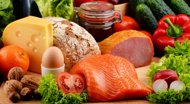 Un bodegón de alimentos saludables como frutos secos, salmón, verduras, huevo y queso. Un bodegón de alimentos saludables como frutos secos, salmón, verduras, huevo y queso.