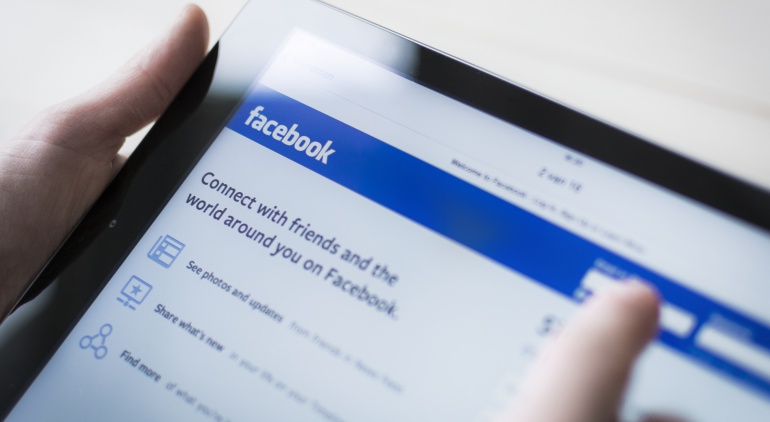 Imagen de una persona sosteniendo una tableta con la web de Facebook en la pantalla. Imagen de una persona sosteniendo una tableta con la web de Facebook en la pantalla.