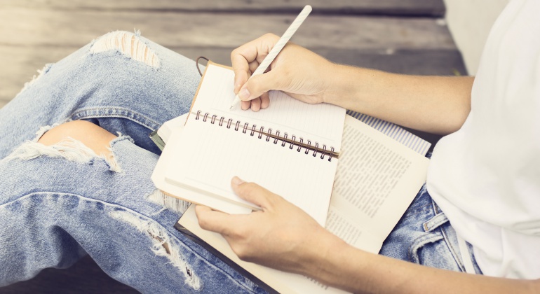 Imagen de una chica escribiendo en un cuaderno. Imagen de una chica escribiendo en un cuaderno.