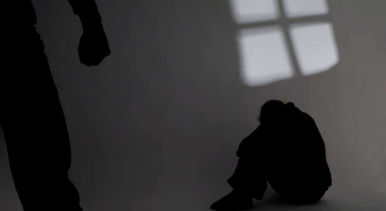 Imagen de la silueta de un hombre en actitud amenazante frente a la silueta de una mujer agazapada. Imagen de la silueta de un hombre en actitud amenazante frente a la silueta de una mujer agazapada.