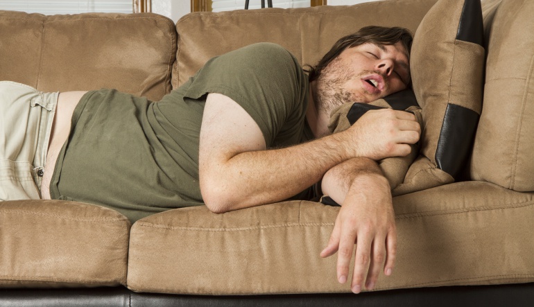 Imagen de un chico durmiendo la siesta a pierna suelta en un sofá. Imagen de un chico durmiendo la siesta a pierna suelta en un sofá.