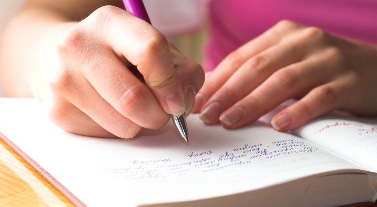 Imagen de una chica escribiendo en un cuaderno. Imagen de una chica escribiendo en un cuaderno.