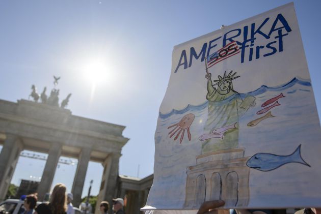 Un manifestante sostiene un cartel en el que se lee 'America SOS primero', durante las protestas contra la salida de Estados Unidos del Acuerdo de París Un manifestante sostiene un cartel en el que se lee 'America SOS primero', durante las protestas contra la salida de Estados Unidos del Acuerdo de París