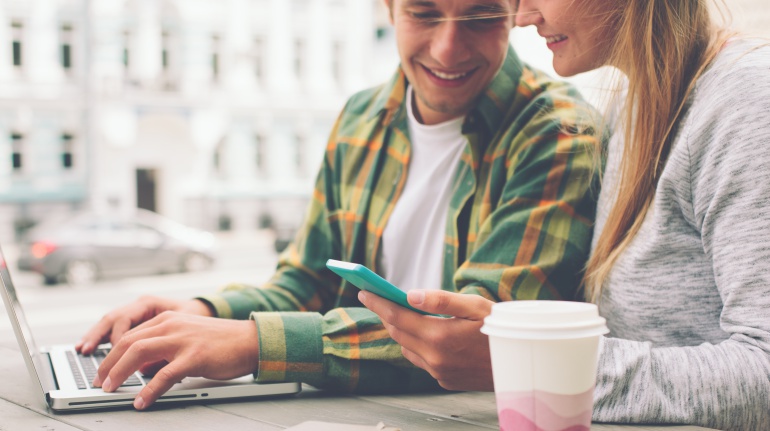 Imagen de un chico con un ordenador y una chica con un teléfono inteligente. Imagen de un chico con un ordenador y una chica con un teléfono inteligente.