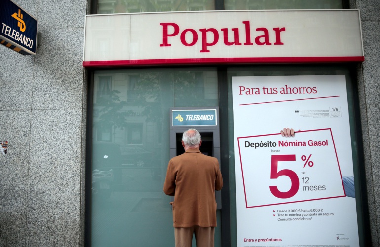 Un hombre frente a un cajero automático de Banco Popular Un hombre frente a un cajero automático de Banco Popular