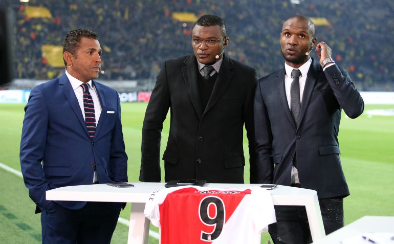 Abidal con Sonny Anderson y Desailly con una camiseta de Falcao en la mesa durante una retransmisión deportiva Abidal con Sonny Anderson y Desailly con una camiseta de Falcao en la mesa durante una retransmisión deportiva