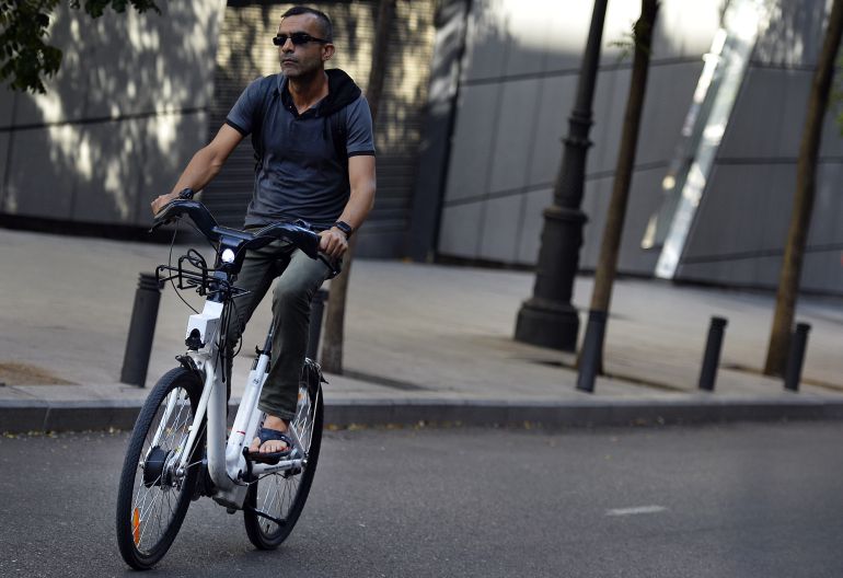 Usuario de bicicleta urbana circulando por una calle en ciudad. Usuario de bicicleta urbana circulando por una calle en ciudad.