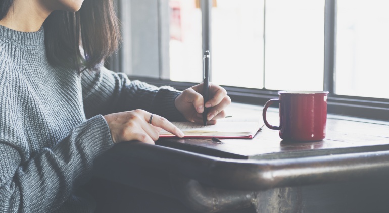 Una mujer escribiendo en un cuaderno Una mujer escribiendo en un cuaderno