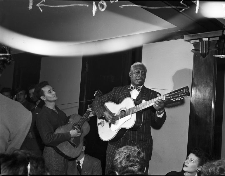Woody Guthrie y Lead Belly en 1940 durante una actuación en un apartamento de Chicago para recaudar fondos para el Comité de las Artes y las Ciencias. Woody Guthrie y Lead Belly en 1940 durante una actuación en un apartamento de Chicago para recaudar fondos para el Comité de las Artes y las Ciencias.