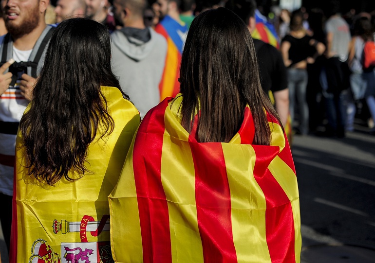 Dos chicas con banderas de España y Cataluña a la espalda Dos chicas con banderas de España y Cataluña a la espalda