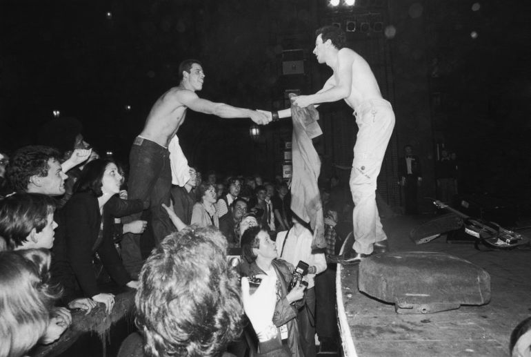 Joe Strummer (1952 - 2002), líder de The Clash, intercambia la camiseta con un seguidor en The Rainbow Theatre de Londres durante un concierto el 14 de mayo de 1977 Joe Strummer (1952 - 2002), líder de The Clash, intercambia la camiseta con un seguidor en The Rainbow Theatre de Londres durante un concierto el 14 de mayo de 1977