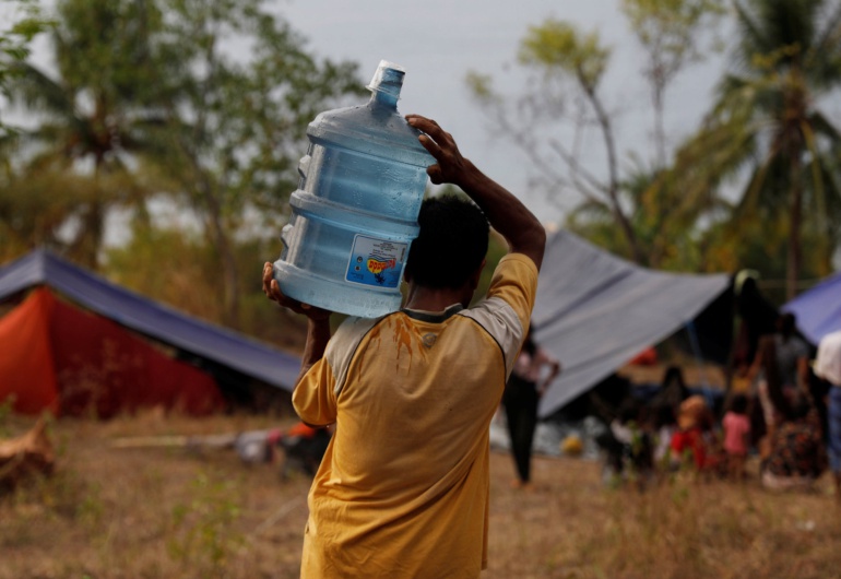 Un habitante de la isla indonesia de Lombok carga una garrafa de agua en uno de los campamentos instalados tras los terremotos Un habitante de la isla indonesia de Lombok carga una garrafa de agua en uno de los campamentos instalados tras los terremotos
