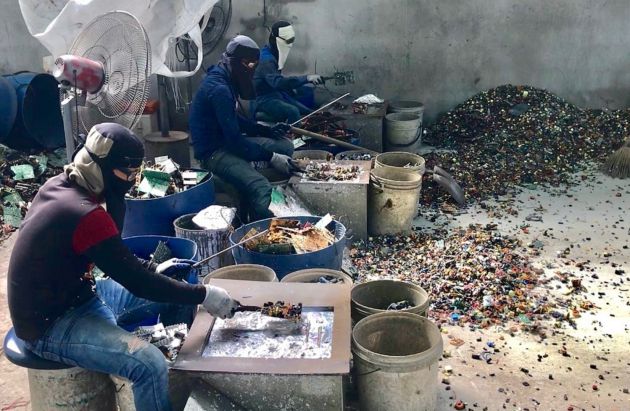 Burmese workers trying to protect themselves from the fume and smoke from the cooking of circuit boards in a primitive site in Thailand receiving e-waste from North America and Europe Burmese workers trying to protect themselves from the fume and smoke from the cooking of circuit boards in a primitive site in Thailand receiving e-waste from North America and Europe