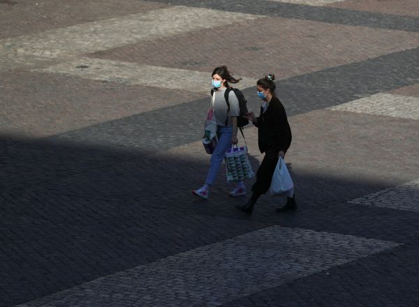 Dos mujeres caminan con mascarillas por la Plaza Mayor de Madrid un día antes de que el Gobierno decretara el Estado de Alarma en España por el coronavirus