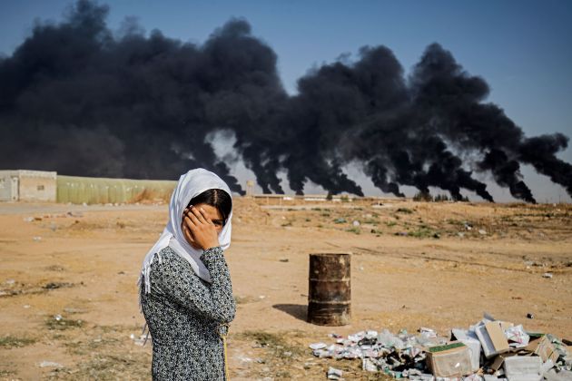 Una niña en el conflicto de Siria con una explosión al fondo. Una niña en el conflicto de Siria con una explosión al fondo.