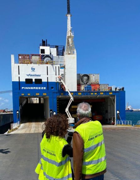 Paqui y Juanjo delante del Finnbreeze que transporta contenedores y maquinaria industrial Paqui y Juanjo delante del Finnbreeze que transporta contenedores y maquinaria industrial
