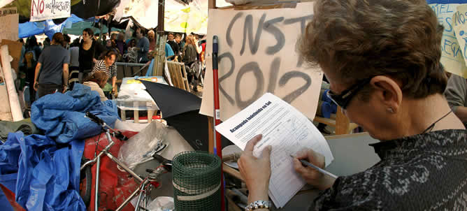 Una mujer deposita su firma en el campamento levantado en la Puerta del Sol de Madrid para apoyar la acampada que se ha organizado allí, prevista hasta el próximo domingo 22 de mayo, día de las elecciones autonómicas y locales. Una mujer deposita su firma en el campamento levantado en la Puerta del Sol de Madrid para apoyar la acampada que se ha organizado allí, prevista hasta el próximo domingo 22 de mayo, día de las elecciones autonómicas y locales.