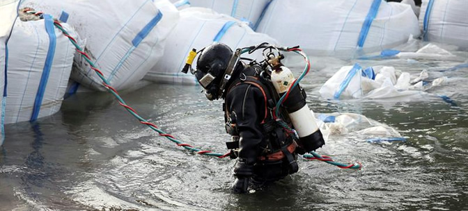 Un submarinista especializado de una empresa de salvamento coloca una barrera de sacos de arena en el río Rin cerca de Coblenza Un submarinista especializado de una empresa de salvamento coloca una barrera de sacos de arena en el río Rin cerca de Coblenza