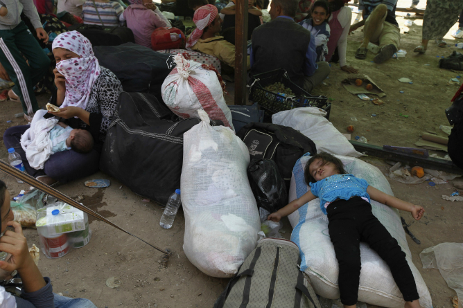 Refugiados sirios que huyen de la violencia en su país, esperan para cruzar la frontera con el norte de Irak Refugiados sirios que huyen de la violencia en su país, esperan para cruzar la frontera con el norte de Irak