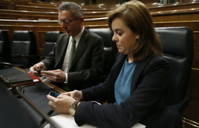 La vicepresidenta del Gobierno, Soraya Sáenz de Santamaría, y el ministro de Justicia, Alberto Ruiz Gallardón, consultan sus teléfonos móviles poco antes del inicio del debate La vicepresidenta del Gobierno, Soraya Sáenz de Santamaría, y el ministro de Justicia, Alberto Ruiz Gallardón, consultan sus teléfonos móviles poco antes del inicio del debate