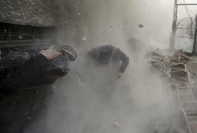 Combatientes del Ejército Libre de Siria corren a esconderse tras la explosión de un tanque en Damasco el 30 de enero 2013. Combatientes del Ejército Libre de Siria corren a esconderse tras la explosión de un tanque en Damasco el 30 de enero 2013.