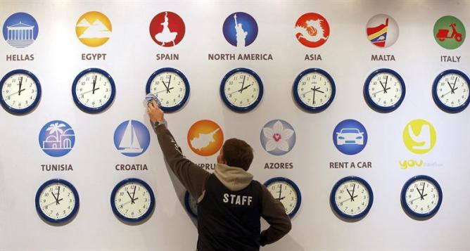 Un trabajador limpia un reloj que refleja la hora en España en la Feria Internacional del Turismo de Berlín (ITB), la mayor del mundo. Un trabajador limpia un reloj que refleja la hora en España en la Feria Internacional del Turismo de Berlín (ITB), la mayor del mundo.