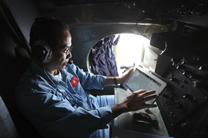 Un oficial trabaja desde un avión de las Fuerzas Armadas de Vietnam durante la operación de búsqueda del vuelo de Malaysia Airlines Un oficial trabaja desde un avión de las Fuerzas Armadas de Vietnam durante la operación de búsqueda del vuelo de Malaysia Airlines