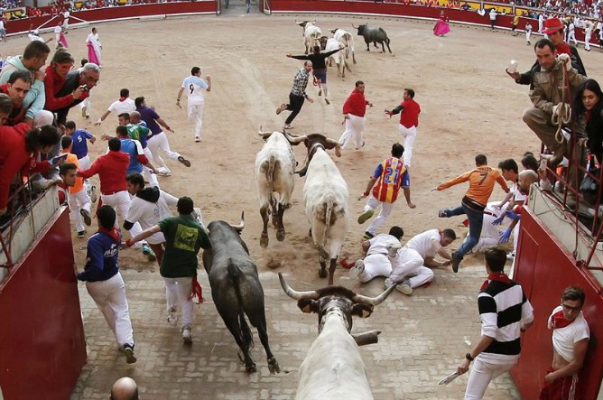 Varios mozos caen ante los toros de la ganadería extremeña de Adolfo Martín Andrés, en la entrada a la plaza de toros, durante el penúltimo encierro de los sanfermines. Varios mozos caen ante los toros de la ganadería extremeña de Adolfo Martín Andrés, en la entrada a la plaza de toros, durante el penúltimo encierro de los sanfermines.