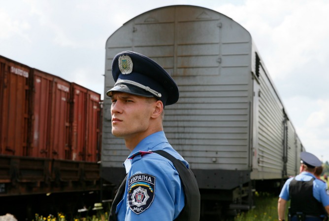 Un policía ucraniano vigila un tren frigorífico con los restos de las víctimas del avión malasio. Un policía ucraniano vigila un tren frigorífico con los restos de las víctimas del avión malasio.