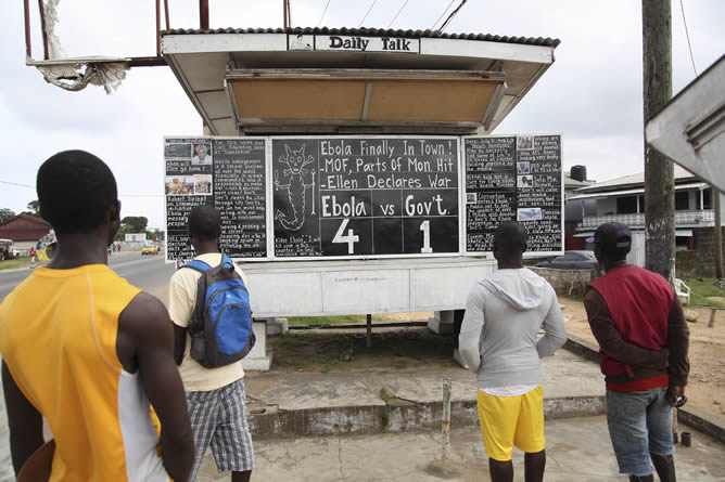 Un grupo de personas observa el tablero que anuncia la cifra de víctimas mortales de Ébola en el país, en una valle de Monrovia (Liberia) Un grupo de personas observa el tablero que anuncia la cifra de víctimas mortales de Ébola en el país, en una valle de Monrovia (Liberia)