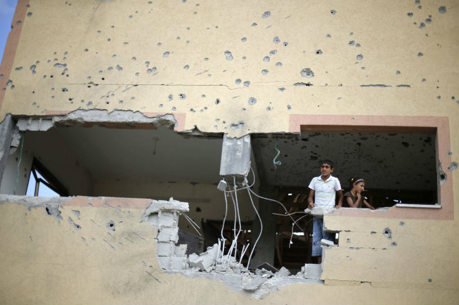 Dos niños palestinos revisan el estado de su casa que ha sido atacada durante la ofensiva militar israelí Dos niños palestinos revisan el estado de su casa que ha sido atacada durante la ofensiva militar israelí