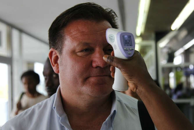 Un voluntario del Instituto Nacional de Salud Pública mide la temperatura a un viajero que llegaba el pasado miércoles a Costa de Marfil, como precaución contra el ébola. Un voluntario del Instituto Nacional de Salud Pública mide la temperatura a un viajero que llegaba el pasado miércoles a Costa de Marfil, como precaución contra el ébola.