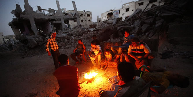 Palestinos se reúnen junto a las ruinas de una edificación en el barrio Al-Shejaeiya al este de Gaza. Palestinos se reúnen junto a las ruinas de una edificación en el barrio Al-Shejaeiya al este de Gaza.