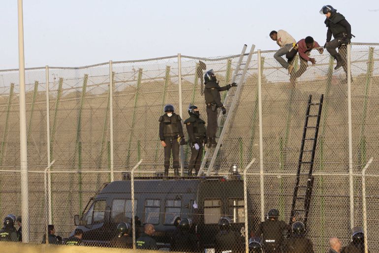 GRA019 MELILLA, 22/10/2014.- Agentes de Policía junto a a algunos de los ochenta inmigrantes que están encaramados desde primera hora a la valla de Melilla, fronteriza con Marruecos, tras el último intento de entrar en la ciudad autonóma protagonizado por varios centenares de subsaharianos, algunos de los cuales, al menos una docena, ha conseguido superar el vallado perimetral.
EFE/Francisco G. Guerrero GRA019 MELILLA, 22/10/2014.- Agentes de Policía junto a a algunos de los ochenta inmigrantes que están encaramados desde primera hora a la valla de Melilla, fronteriza con Marruecos, tras el último intento de entrar en la ciudad autonóma protagonizado por varios centenares de subsaharianos, algunos de los cuales, al menos una docena, ha conseguido superar el vallado perimetral.
EFE/Francisco G. Guerrero