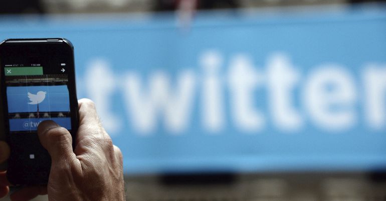 Un hombre fotografía el logotipo de Twitter con su teléfono móvil Un hombre fotografía el logotipo de Twitter con su teléfono móvil