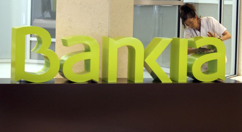 Una operaria limpia el logo de Bankia en la sede central de Bancaja Una operaria limpia el logo de Bankia en la sede central de Bancaja
