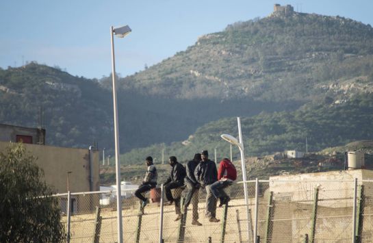African migrants sit at the top of a border fence during an attempt to cross into Spanish territories, between Morocco and Spain's north African enclave of Melilla December 30, 2014. Of the nearly 200 migrants who participated in the attempt, 102 migrants managed to cross the border into Spain, and are currently held at CETI, a short-stay immigrant centre, according to local authorities. REUTERS/Jesus Blasco de Avellaneda (SPAIN - Tags: SOCIETY IMMIGRATION CIVIL UNREST) African migrants sit at the top of a border fence during an attempt to cross into Spanish territories, between Morocco and Spain's north African enclave of Melilla December 30, 2014. Of the nearly 200 migrants who participated in the attempt, 102 migrants managed to cross the border into Spain, and are currently held at CETI, a short-stay immigrant centre, according to local authorities. REUTERS/Jesus Blasco de Avellaneda (SPAIN - Tags: SOCIETY IMMIGRATION CIVIL UNREST)