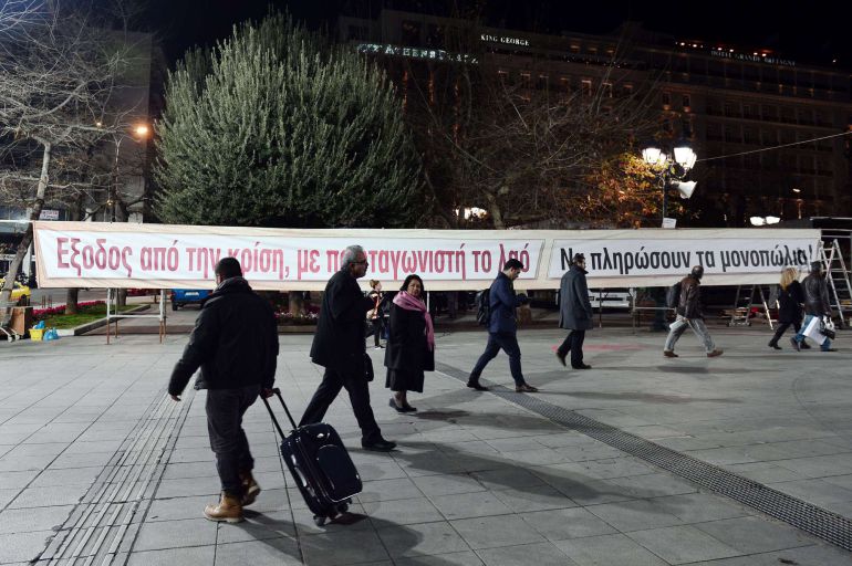 Pancarta que dice "Salir de la crisis con el protagonisto de la gente" colocada en la plaza Syntagma de Atenas. Pancarta que dice "Salir de la crisis con el protagonisto de la gente" colocada en la plaza Syntagma de Atenas.