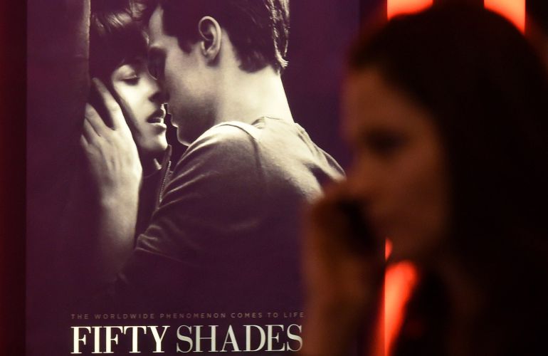 Una joven pasa por el cartel de una de las películas más esperadas del año, 'Cincuentas sombras de Grey'. Una joven pasa por el cartel de una de las películas más esperadas del año, 'Cincuentas sombras de Grey'.