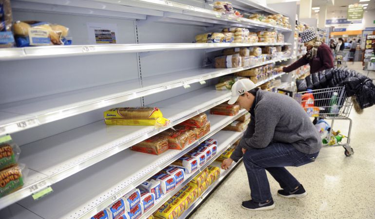 Varias personas hacen la compra en un supermercado Varias personas hacen la compra en un supermercado