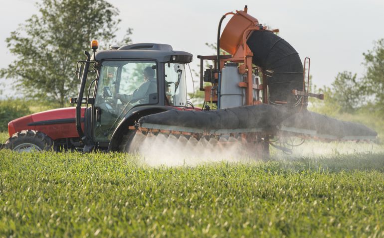 Un agricultor realiza una trabajo en un campo agrícola Un agricultor realiza una trabajo en un campo agrícola